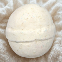 White bath bomb on a textured beige surface