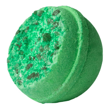 Green bath bomb with specks on a white background
