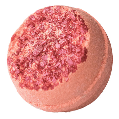 Pink bath bomb with red speckles on a white background