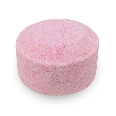 Pink bath bomb with speckles on a white background