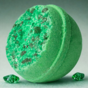 Green bath bomb with specks on a gray background