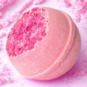 Pink bath bomb with a textured surface on a pink background