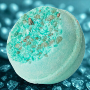 Bath bomb with green crumbly top on a blue background