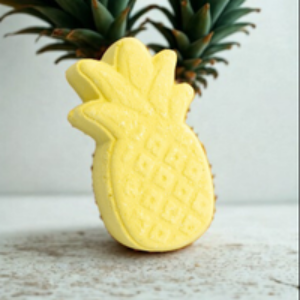 Yellow pineapple-shaped object on a light wooden surface with a blurred background