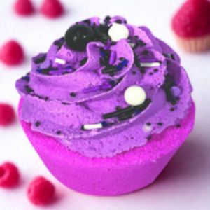 Purple bath bomb with black and white decorative elements on a white background with raspberries.