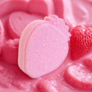 Pink heart-shaped macaron with a strawberry on a pink background