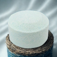 White round object on a textured brown and blue surface with a gray background