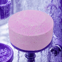Pink bath bomb with water droplets on a purple background
