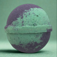 Green and purple bath bomb on a green background