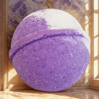 Purple bath bomb with a white top on a wooden surface