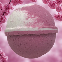 Pink bath bomb with a white center on a pink cherry blossom background