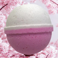 Pink bath bomb with a white sphere on a pink cherry blossom background