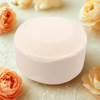 Round pink object on a white surface with orange flowers