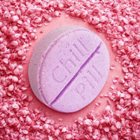 Pink bath bomb with a purple stripe on a pink textured background