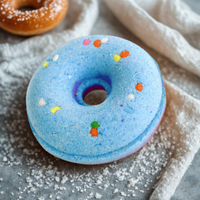 Blue donut with colorful sprinkles on a textured surface