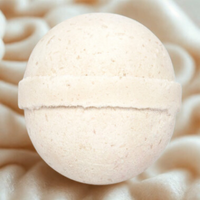 White bath bomb on a textured beige surface